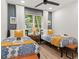 Charming bedroom with twin beds, natural light, ceiling fan and bright yellow accents at 521 Smithstone Se Rd, Marietta, GA 30067
