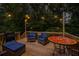 Outdoor deck furnished with cozy seating and a decorative table, illuminated by ambient string lights for serene evenings at 521 Smithstone Se Rd, Marietta, GA 30067