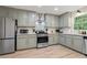 Well-appointed kitchen with stainless steel appliances, updated lighting, and gray tone cabinets at 521 Smithstone Se Rd, Marietta, GA 30067
