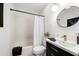 Stylish bathroom with modern vanity, round mirror, and shower-tub combination at 1612 Alder Se Ct, Atlanta, GA 30317
