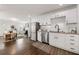 Well-designed kitchen with stainless steel appliances, granite countertops, white cabinetry, and hardwood floors at 1612 Alder Se Ct, Atlanta, GA 30317