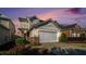 Charming two-story home with a two-car garage, stone accents, and landscaped front yard at dusk at 2206 Palomino Ln, Conyers, GA 30012