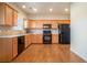 Well-lit kitchen with wood cabinets, black appliances, tile backsplash, and hardwood floors at 2206 Palomino Ln, Conyers, GA 30012