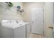 Laundry room with new white washer and dryer, storage shelf, and access door at 2206 Palomino Ln, Conyers, GA 30012