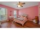 Charming pink bedroom with natural light, a cozy bed, and stylish decor for a serene retreat at 4128 Mayflower Sw Ct, Lilburn, GA 30047