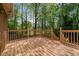 Spacious wooden deck with railings, perfect for outdoor entertaining and enjoying the wooded view at 4128 Mayflower Sw Ct, Lilburn, GA 30047