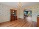 Dining room featuring floral wallpaper, hardwood floors, and decorative furniture at 4128 Mayflower Sw Ct, Lilburn, GA 30047
