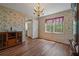 Dining room with floral wallpaper, hardwood floors, chandelier, and window views at 4128 Mayflower Sw Ct, Lilburn, GA 30047