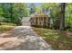 Two-story brick home with manicured lawn, columns, mature trees, and long driveway at 4128 Mayflower Sw Ct, Lilburn, GA 30047