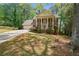 Two-story brick home featuring mature trees, a manicured lawn, and a garage at 4128 Mayflower Sw Ct, Lilburn, GA 30047