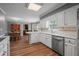 Traditional kitchen features white cabinetry, stainless appliances, and hardwood flooring at 4128 Mayflower Sw Ct, Lilburn, GA 30047