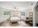 Bright bedroom featuring a four-poster bed, ceiling fan, and natural light from the windows at 1548 Highway 81 W, Mcdonough, GA 30253