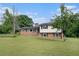 Classic two-story home featuring a brick facade, black shutters, and a spacious lawn with mature trees at 1548 Highway 81 W, Mcdonough, GA 30253