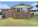 Rear exterior of brick home with a covered area, lawn and some exterior storage at 1548 Highway 81 W, Mcdonough, GA 30253