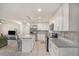 Open kitchen boasts white cabinets, stainless steel appliances, a granite island and an inviting atmosphere at 1548 Highway 81 W, Mcdonough, GA 30253