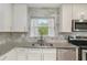 Close-up of a kitchen with granite counters, stainless steel sink, and white cabinets, creating a clean and functional space at 1548 Highway 81 W, Mcdonough, GA 30253