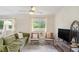 Bright living room is furnished with comfortable seating, a ceiling fan, and a view of the outdoors at 1548 Highway 81 W, Mcdonough, GA 30253