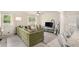 Bright living room featuring a plush green sectional sofa, neutral decor, and ample natural light from large windows at 1548 Highway 81 W, Mcdonough, GA 30253