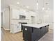 Stylish kitchen with white cabinets, stainless steel appliances, dark island, and pendant lighting at 158 Bluffington Way, Marietta, GA 30066
