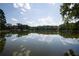 A scenic lake view with mirror-like water reflecting the blue sky and trees surrounding it at 1800 Jordan Brook Dr, Lawrenceville, GA 30043