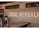 Interior view of the Local Republic Restaurant brick wall with the name in metal lettering at 1800 Jordan Brook Dr, Lawrenceville, GA 30043