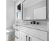 Bathroom features a white vanity with a marble countertop, a black mirror, and modern fixtures at 407 Thunder Rd, Buford, GA 30518