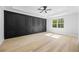This bedroom offers a black accent wall with paneling, tray ceilings, and a ceiling fan at 407 Thunder Rd, Buford, GA 30518