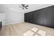 This bedroom features a black paneled accent wall, tray ceilings, a ceiling fan, and modern design at 407 Thunder Rd, Buford, GA 30518