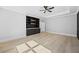 This bedroom features a built-in unit with shelving and cabinets, tray ceilings, and a ceiling fan at 407 Thunder Rd, Buford, GA 30518