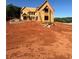 Exterior view of new home under construction showcasing framing, windows, and ladder at 407 Thunder Rd, Buford, GA 30518