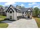Beautiful white brick home with contrasting black trim, a modern design, and ample driveway space at 407 Thunder Rd, Buford, GA 30518
