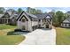 Elegant white brick home with black roof accents and trim, featuring a spacious three-car garage at 407 Thunder Rd, Buford, GA 30518