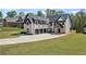 Stunning white brick home featuring black accents, three-car garage, and well-manicured lawn at 407 Thunder Rd, Buford, GA 30518