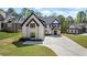 Elegant white brick home with black roof accents and trim, featuring a spacious three-car garage at 407 Thunder Rd, Buford, GA 30518