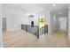 Elegant hallway featuring hardwood floors, decorative chandelier, and iron railings at 407 Thunder Rd, Buford, GA 30518