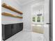 Hallway with marble floors, floating shelves, and a doorway leading to a room with plenty of natural light at 407 Thunder Rd, Buford, GA 30518