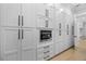 Bright white kitchen cabinets with black hardware flank stainless steel microwave, oven and drawers at 407 Thunder Rd, Buford, GA 30518