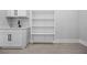 Cozy laundry room featuring a built-in sink with white cabinets and shelving at 407 Thunder Rd, Buford, GA 30518