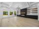 Beautiful living room with a modern fireplace, built-in shelves, coffered ceilings, and hardwood floors at 407 Thunder Rd, Buford, GA 30518