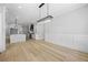 Spacious living room with hardwood floors, white walls, and open floor plan into modern kitchen at 407 Thunder Rd, Buford, GA 30518