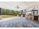 Covered patio featuring an outdoor kitchen and serene view of the fenced backyard at 407 Thunder Rd, Buford, GA 30518