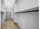 Bright walk-in closet with built-in shelving and wood flooring at 407 Thunder Rd, Buford, GA 30518