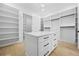 Large walk-in closet boasts custom shelving, center island, and hardwood floors at 407 Thunder Rd, Buford, GA 30518
