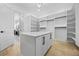 Bright walk-in closet features custom shelving, center island, and hardwood floors at 407 Thunder Rd, Buford, GA 30518