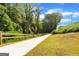 Scenic walking path with a wooden fence surrounded by lush green trees and foliage at 407 Thunder Rd, Buford, GA 30518