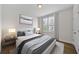 Staged bedroom featuring a queen bed, two side tables, lamps, and a large window at 1227 Cushenberry Ln, Atlanta, GA 30318