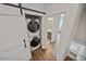 A stacked, front load washer and dryer is hidden behind a sliding barn door at 1227 Cushenberry Ln, Atlanta, GA 30318