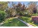 Lush backyard featuring mature trees, a stone path, manicured lawn and vibrant azaleas for an outdoor lifestyle at 1012 Bellevue Ne Dr, Atlanta, GA 30306