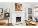 Living room fireplace with white brick surround and hearth, flanked by curated artwork and built-in shelving at 1012 Bellevue Ne Dr, Atlanta, GA 30306