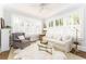 Bright living room with large windows, white shutters, hardwood floors, and neutral-toned furniture for a relaxing atmosphere at 1012 Bellevue Ne Dr, Atlanta, GA 30306